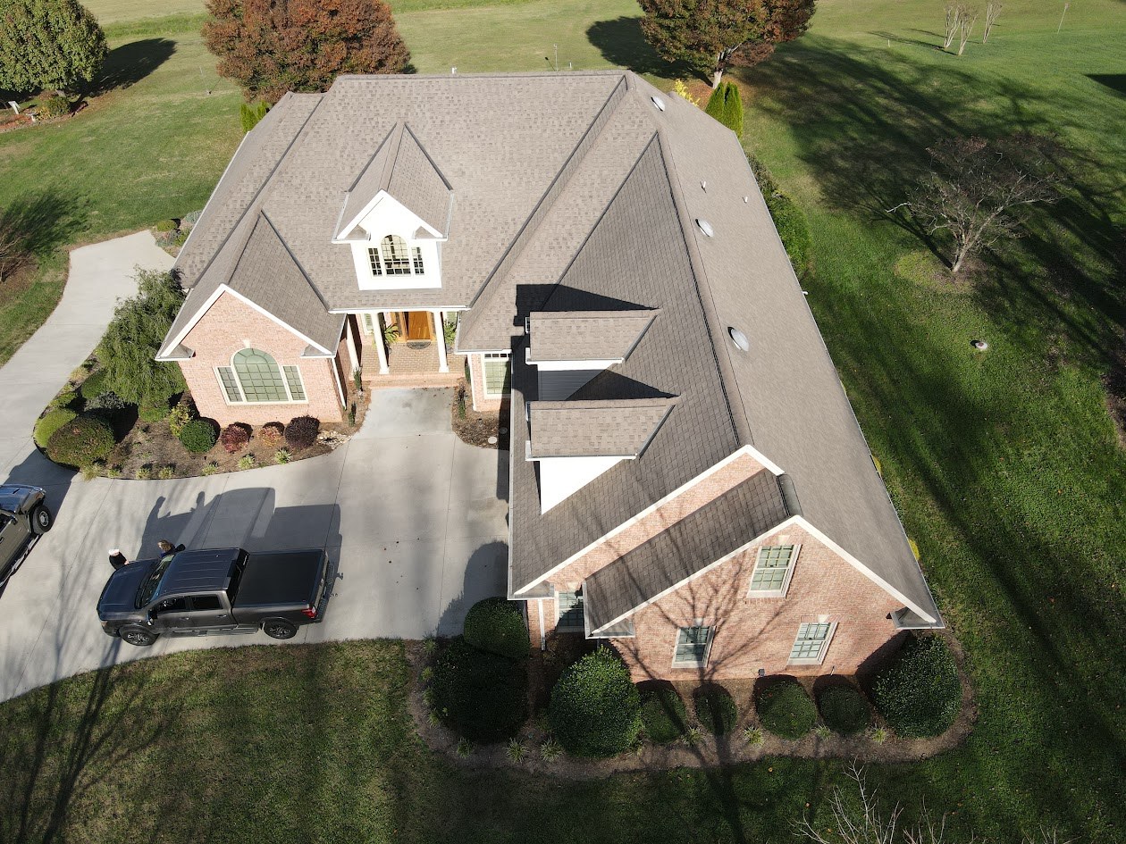 Aerial view of a brick custom home with a new roof