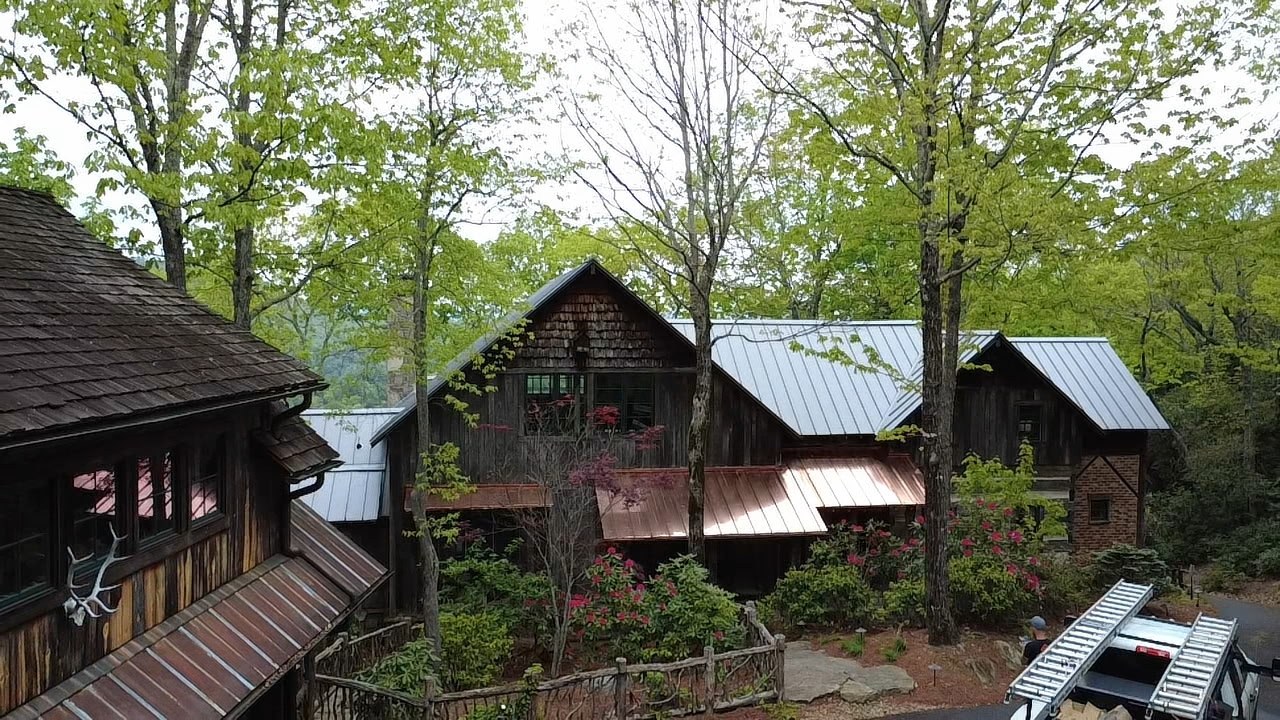 Rustic timber custom home with metal roof and copper accents