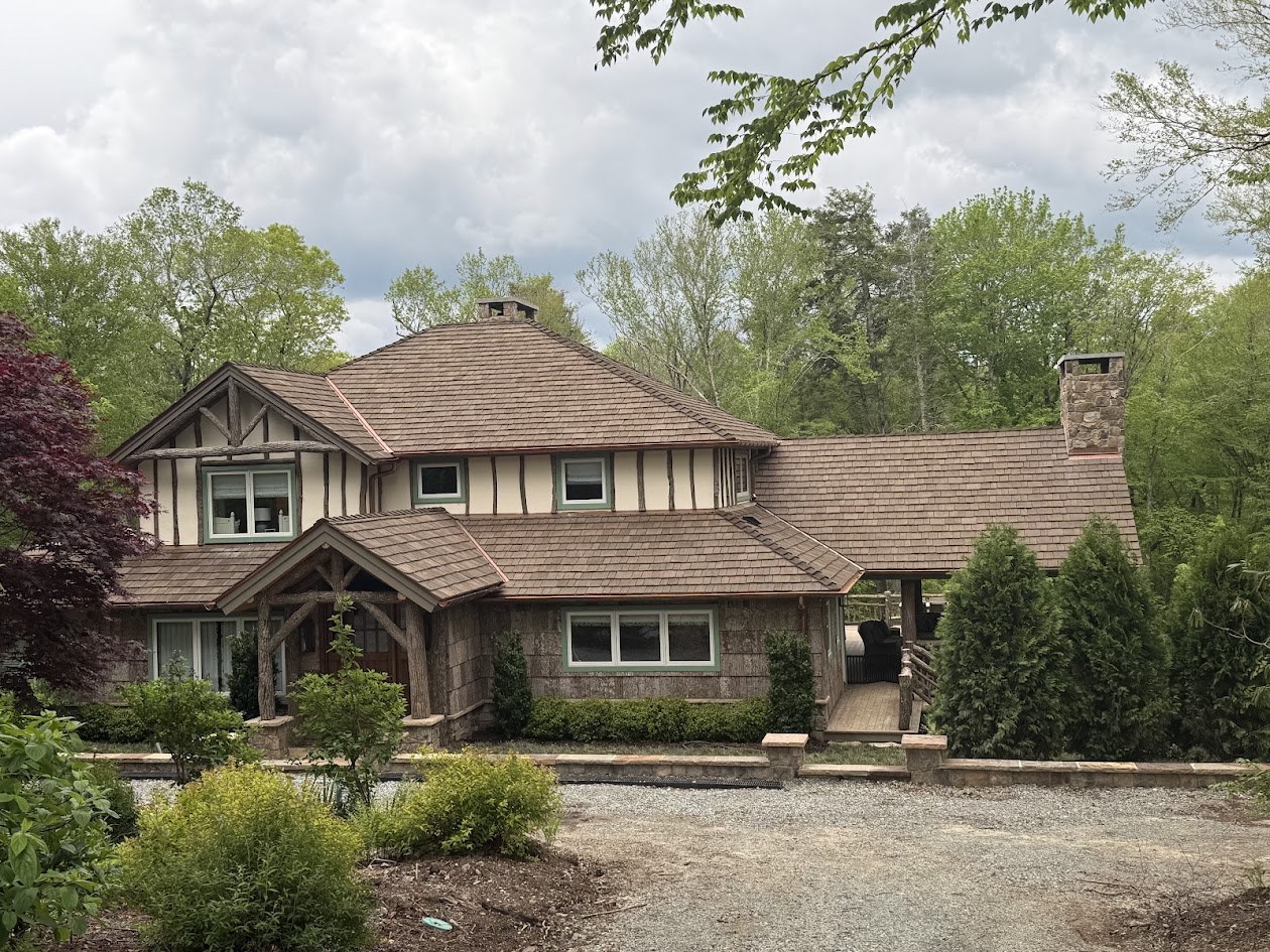 Tudor-style custom home with cedar shingle roof and timber framing