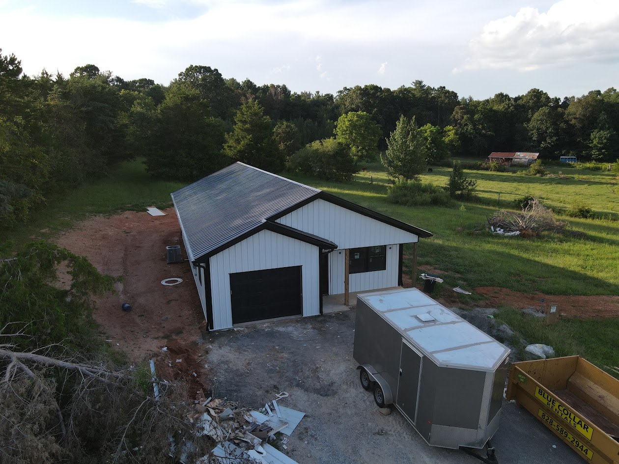 Custom home with white metal siding and black trim