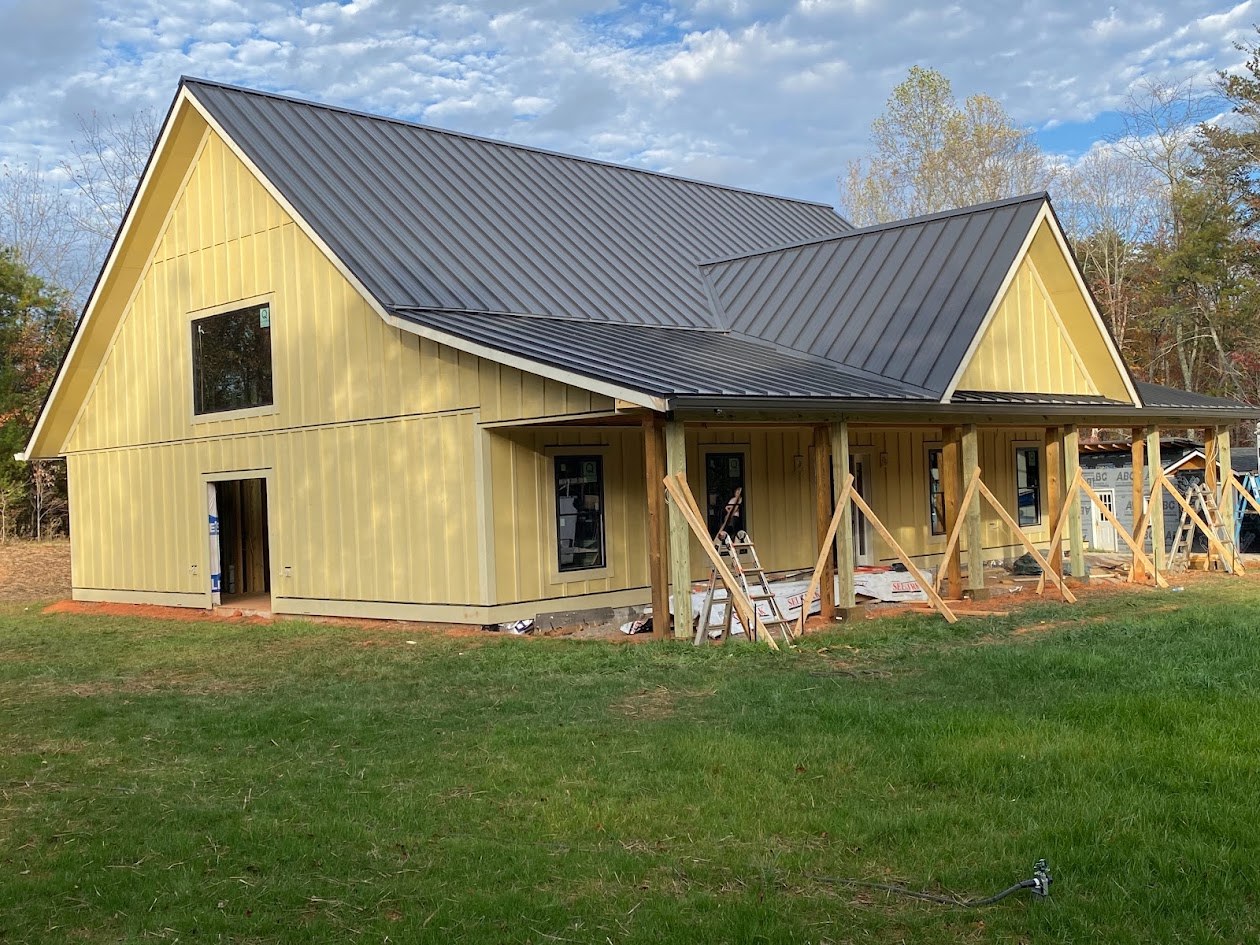 Custom home with board-and-batten siding and covered porch under construction