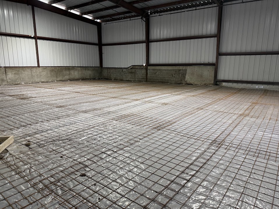 Wire mesh reinforcement over a vapor barrier prepared for a concrete slab pour